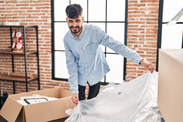 Young Hispanic Man Smiling Confident Unpacking Sofa New Home — Stockfoto