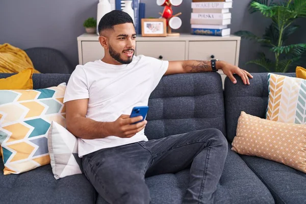 Mladý Latin Muž Pomocí Smartphone Sedí Pohovce Doma — Stock fotografie
