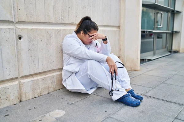 Young Beautiful Size Woman Doctor Stressed Sitting Floor Hospital — Stock fotografie
