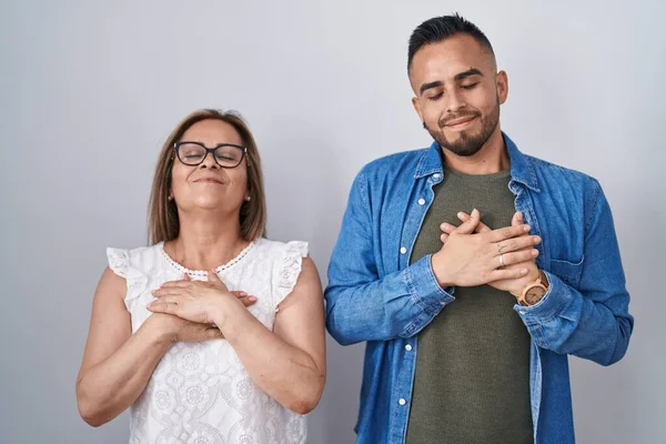 Hispanic Mor Och Son Står Tillsammans Leende Med Händerna Bröstet — Stockfoto