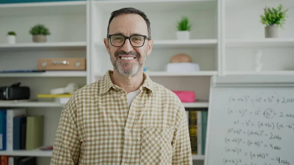 Middle age man teacher smiling confident standing at classroom