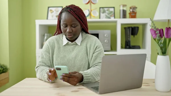 Afrikanerin Mit Geflochtenen Haaren Sitzt Mit Smartphone Auf Dem Tisch — Stockfoto