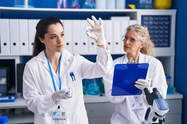 Duas Mulheres Cientistas Segurando Pílulas Escrevem Documento Laboratório — Fotografia de Stock