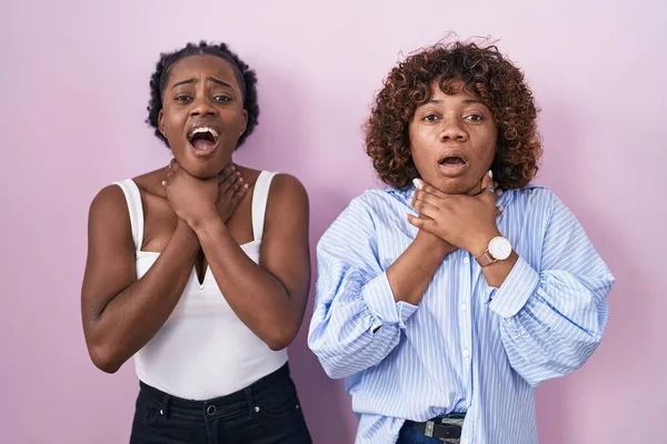 Две Африканки Стоящие Розовом Фоне Кричащие Задыхаются Болезненного Удушения Проблемы — стоковое фото