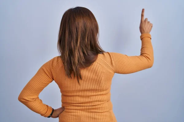 오렌지 스웨터를 중년의 여자가 손가락으로 포즈를 취하고 — 스톡 사진