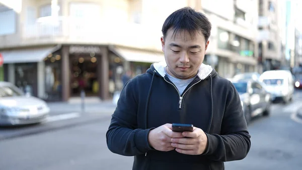 Mladý Číňan Pomocí Smartphone Uvolněným Výrazem Ulici — Stock fotografie