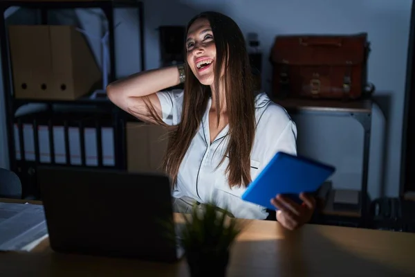 Geceleri Ofiste Çalışan Esmer Bir Kadın Gülümsüyor Saçlarına Dokunuyor Hareketi — Stok fotoğraf