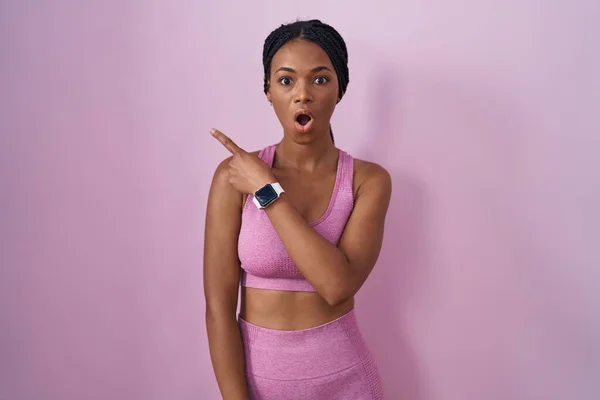 Африканская Американка Косичками Спортивной Одежде Розовом Фоне Удивлен Показывая Пальцем — стоковое фото