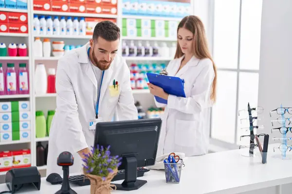 Man Woman Pharmacists Using Computer Writing Document Pharmacy — ストック写真
