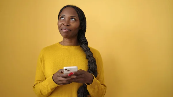 Африканська Жінка Посміхається Допомогою Смартфона Над Ізольованим Жовтим Фоном — стокове фото