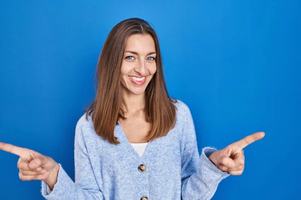 Young Woman Standing Blue Background Smiling Confident Pointing Fingers Different —  Fotos de Stock