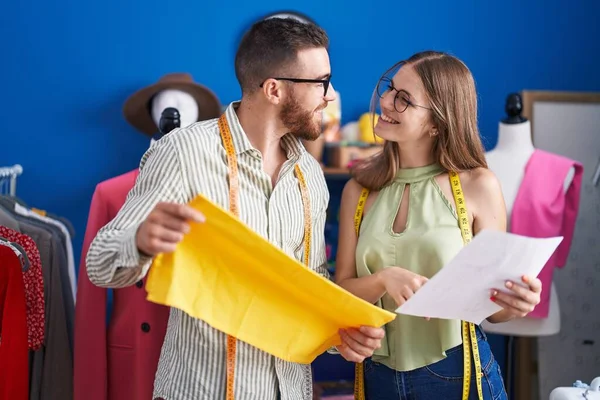 stock image Man and woman tailors holding cloth looking clothing design at clothing factory