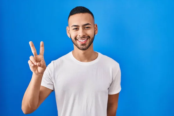 Young Hispanic Man Standing Blue Background Smiling Looking Camera Showing — Fotografia de Stock