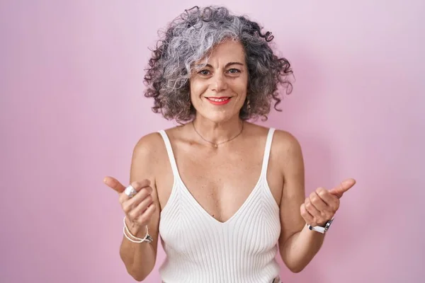 Kobieta Średnim Wieku Siwymi Włosami Stojąca Różowym Tle Znak Sukcesu — Zdjęcie stockowe