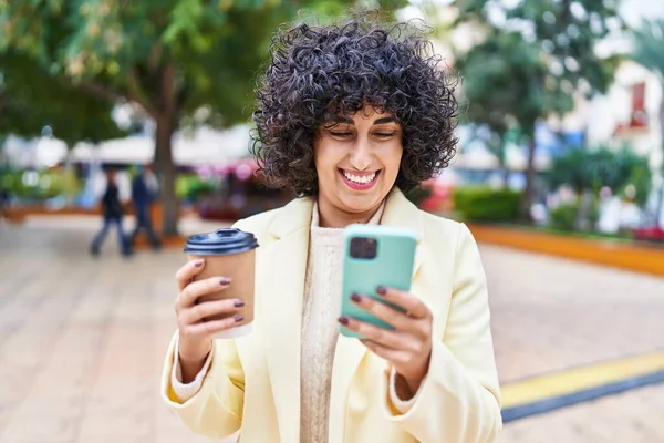 年轻的中东女人喜欢在公园用智能手机喝咖啡 — 图库照片