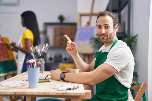 Hispanic Man Painter Studio Smiling Happy Pointing Hand Finger Side — ストック写真