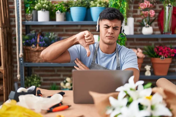 在花店工作的西班牙裔年轻人 满脸怒容 脸上挂着厌恶大拇指的负面标志 被拒绝的念头 — 图库照片