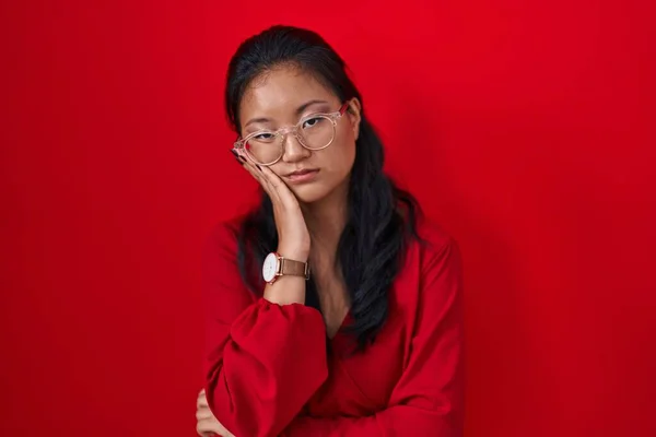 Aziatische Jonge Vrouw Staan Rode Achtergrond Denken Kijken Moe Verveeld — Stockfoto