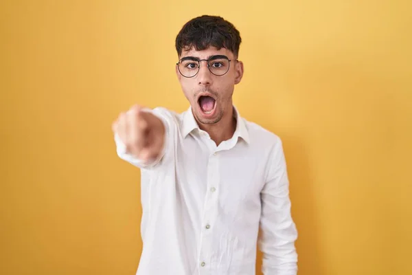Young Hispanic Man Standing Yellow Background Pointing Finger Surprised Ahead — Stockfoto