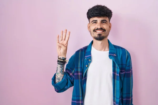 Молодой Латиноамериканец Бородой Стоит Розовом Фоне Показывает Пальцами Номер Четыре — стоковое фото