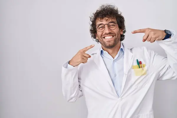 Der Hispanische Junge Mann Doktoruniform Lächelt Fröhlich Und Zeigt Mit — Stockfoto
