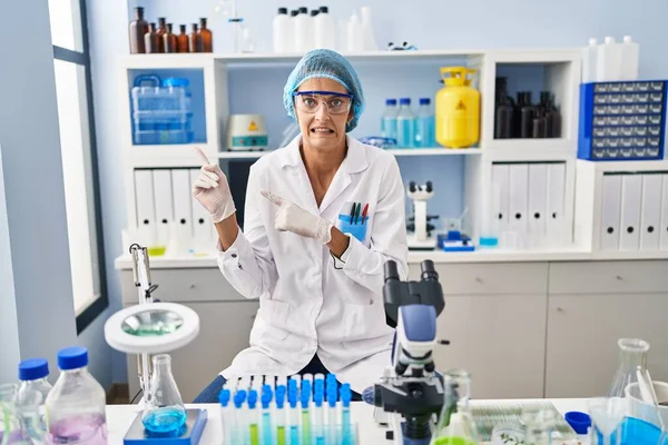 Brunette Woman Working Scientist Laboratory Pointing Aside Worried Nervous Both — Stock Photo, Image