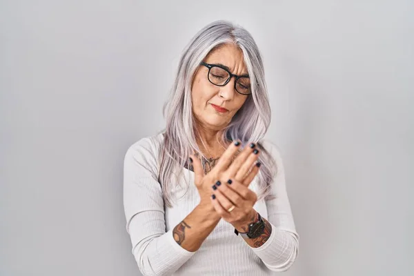 白い背景の上に立つ白髪の中年女性手や指の痛み 関節炎の炎症 — ストック写真