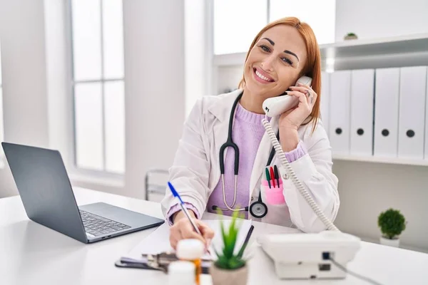 Jovem Caucasiana Médico Falando Por Telefone Escrevendo Relatório Médico Clínica — Fotografia de Stock