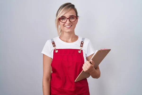 Młoda Blondynka Mundurze Kelnera Trzymająca Notatnik Szczęśliwym Chłodnym Uśmiechem Twarzy — Zdjęcie stockowe
