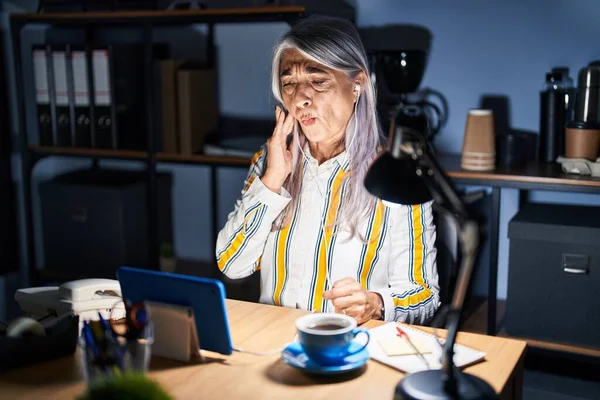 Orta Yaşlı Kır Saçlı Bir Kadın Gece Ofiste Çalışıyor Diş — Stok fotoğraf
