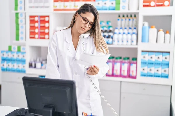 Young Hispanic Woman Pharmacist Talking Telephone Reading Prescription Pharmacy — Stockfoto