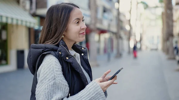 年轻美丽的惊慌失措的女人在街上用智能手机充满自信地微笑 — 图库照片