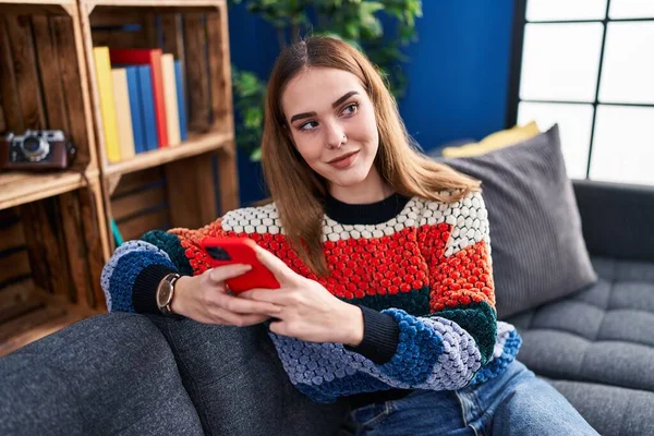 Mujer Joven Usando Teléfono Inteligente Sentado Sofá Casa —  Fotos de Stock