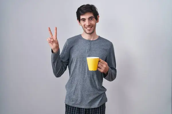Молодий Іспаномовний Чоловік Піжамі Чашку Кави Посміхаючись Щасливим Обличчям Підморгнувши — стокове фото
