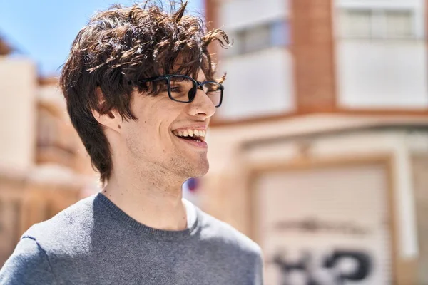 年轻的惊慌失措的男人带着眼镜在街上微笑 — 图库照片
