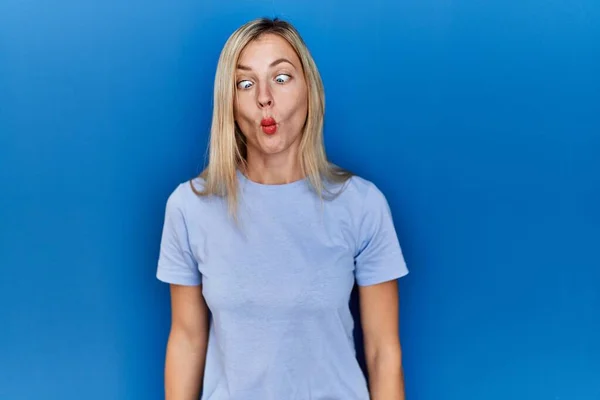Mooie Blonde Vrouw Draagt Casual Shirt Blauwe Achtergrond Vissengezicht Met — Stockfoto