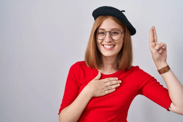 Genç Kızıl Saçlı Gözlüklü Bereli Gülümseyen Elleri Göğsünde Parmakları Havada — Stok fotoğraf