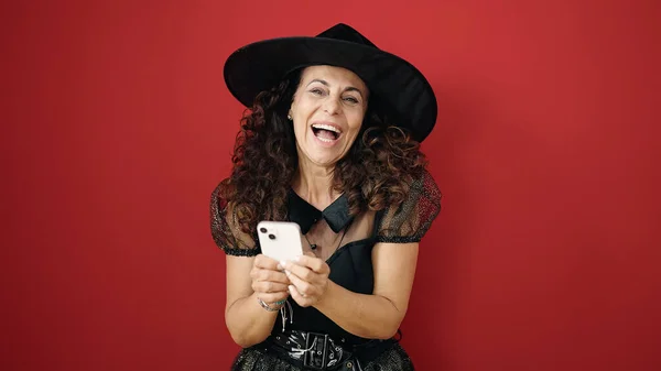 Middle Age Hispanic Woman Wearing Witch Costume Using Smartphone Isolated — Stockfoto