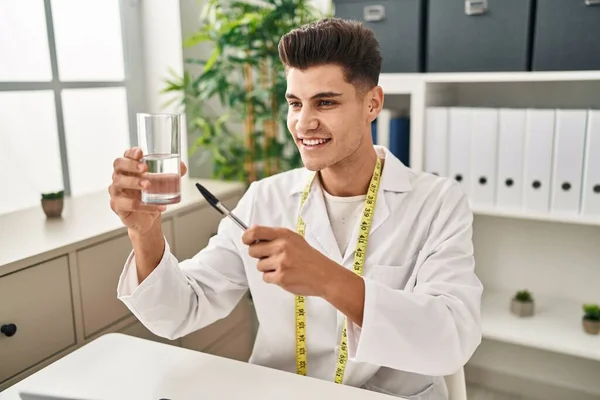Young Hispanic Man Wearing Dietician Uniform Holding Water Glass Clinic — Photo