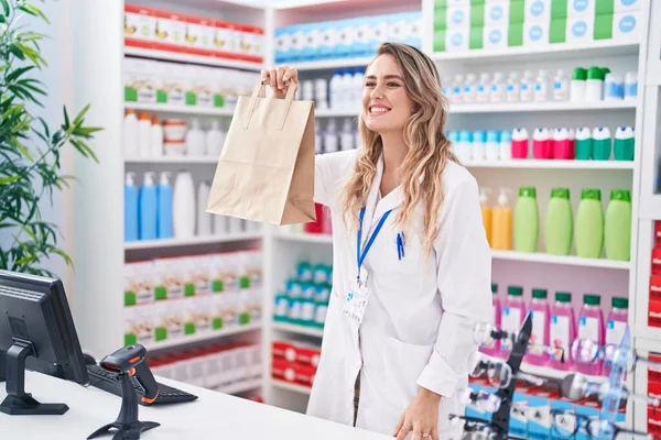 Young Blonde Woman Pharmacist Smiling Confident Holding Shopping Bag Pharmacy — Foto Stock