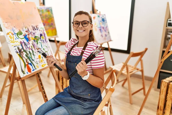 年轻女子自信地微笑着 手握画笔在艺术工作室里 — 图库照片