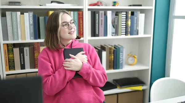 Joven Mujer Rubia Estudiante Abrazando Libro Sentado Mesa Biblioteca Universidad — Foto de Stock