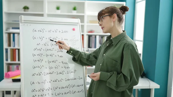 図書館大学で磁気ボード上の数学を教える若い白人女性 — ストック写真