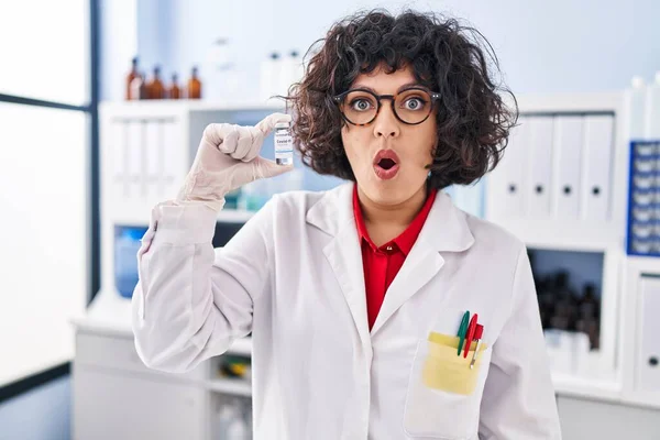 Hispanic Doctor Woman Curly Hair Holding Vaccine Scared Amazed Open — Stock Photo, Image