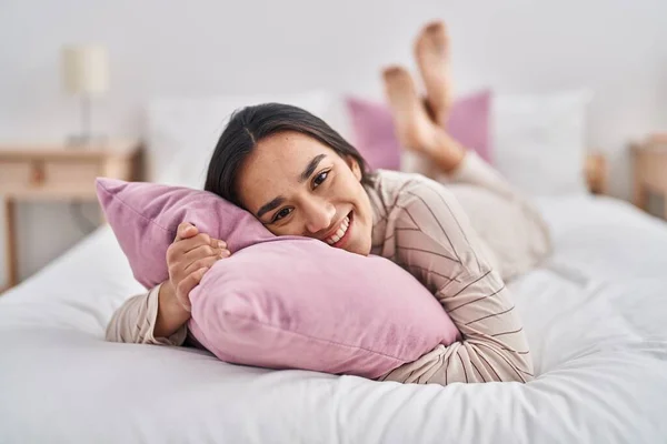 Young Hispanic Woman Hugging Pillow Lying Bed Bedroom — Zdjęcie stockowe