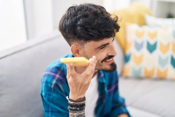 Ung Latinamerikan Man Lyssnar Ljud Meddelande Smartphone Sitter Soffan Hemma — Stockfoto