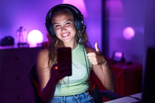 Молодая Латиноамериканка Играет Видеоигры Смартфоном Улыбаясь Счастливой Позитивной Большой Палец — стоковое фото