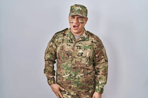 Hispanic Young Man Wearing Camouflage Army Uniform Winking Looking Camera — Zdjęcie stockowe