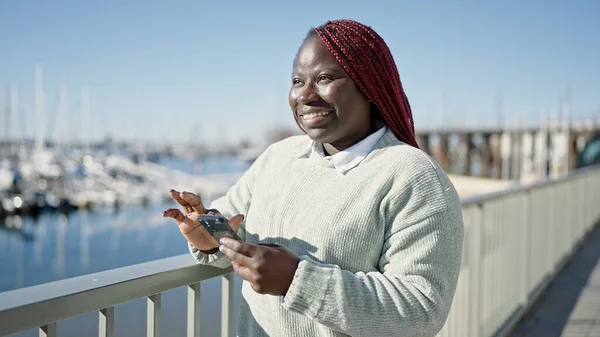 海辺でスマートフォンを使用して編組髪アフリカの女性 — ストック写真