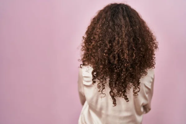 Латиноамериканка Кучерявим Волоссям Стоїть Над Рожевим Фоном Дивлячись Назад Перехрещеними — стокове фото